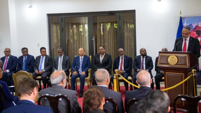 Haiti TPC seated as Didier Fils-Aime speaks at podium
